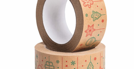 rouleaux d'adhésif Noël pour fermeture colis, posés sur une planche avec de la farine et des biscuits pain d'épice